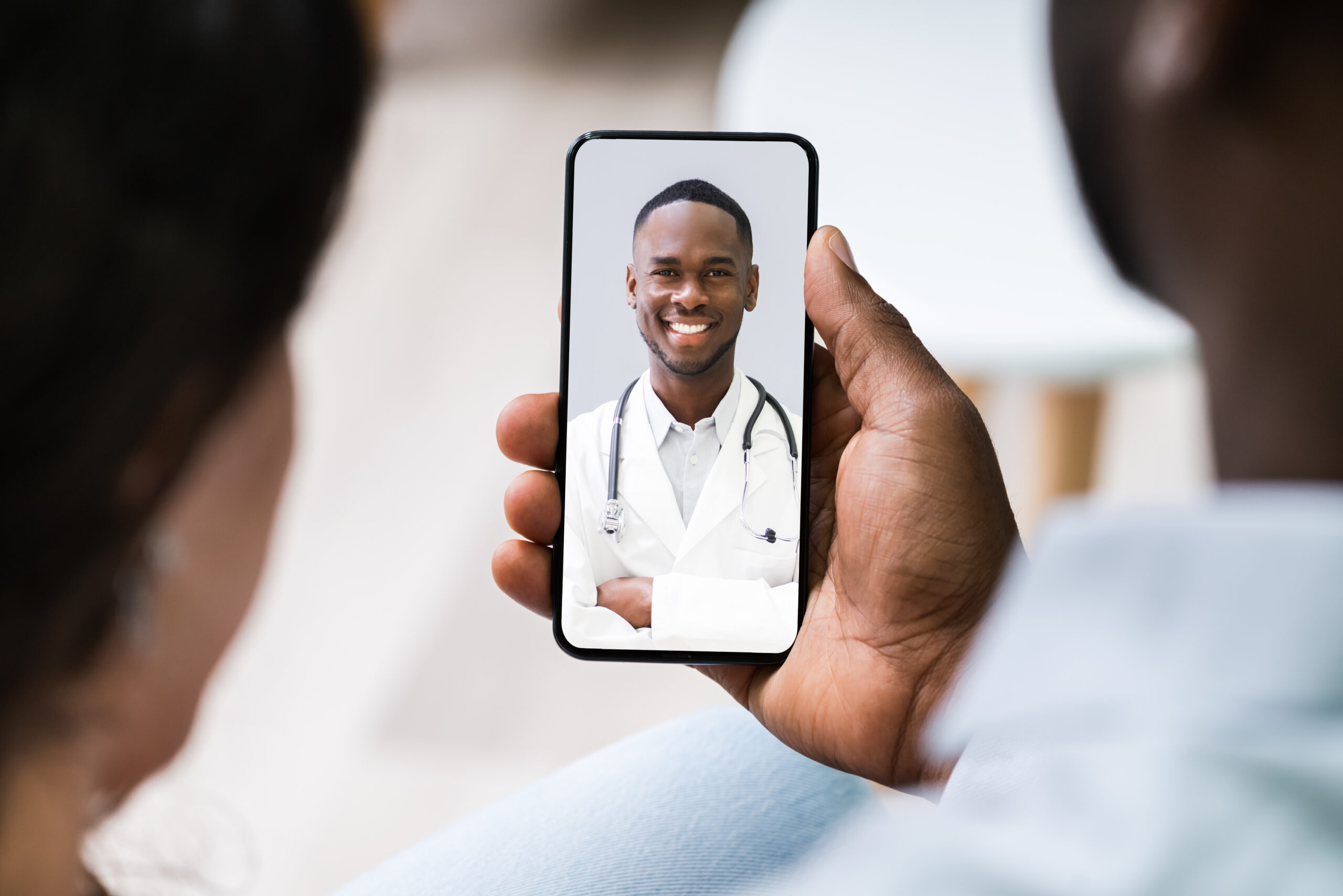Couple,Having,Video,Chat,With,Doctor,On,Mobile,Phone,At